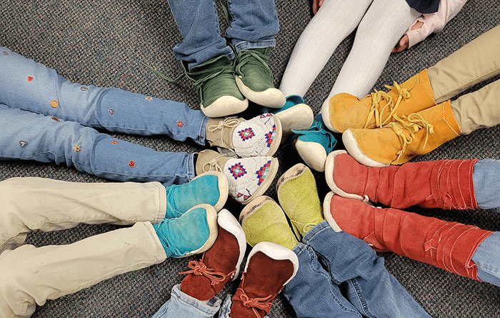 Kids legs with color shoes arranged in a circle.